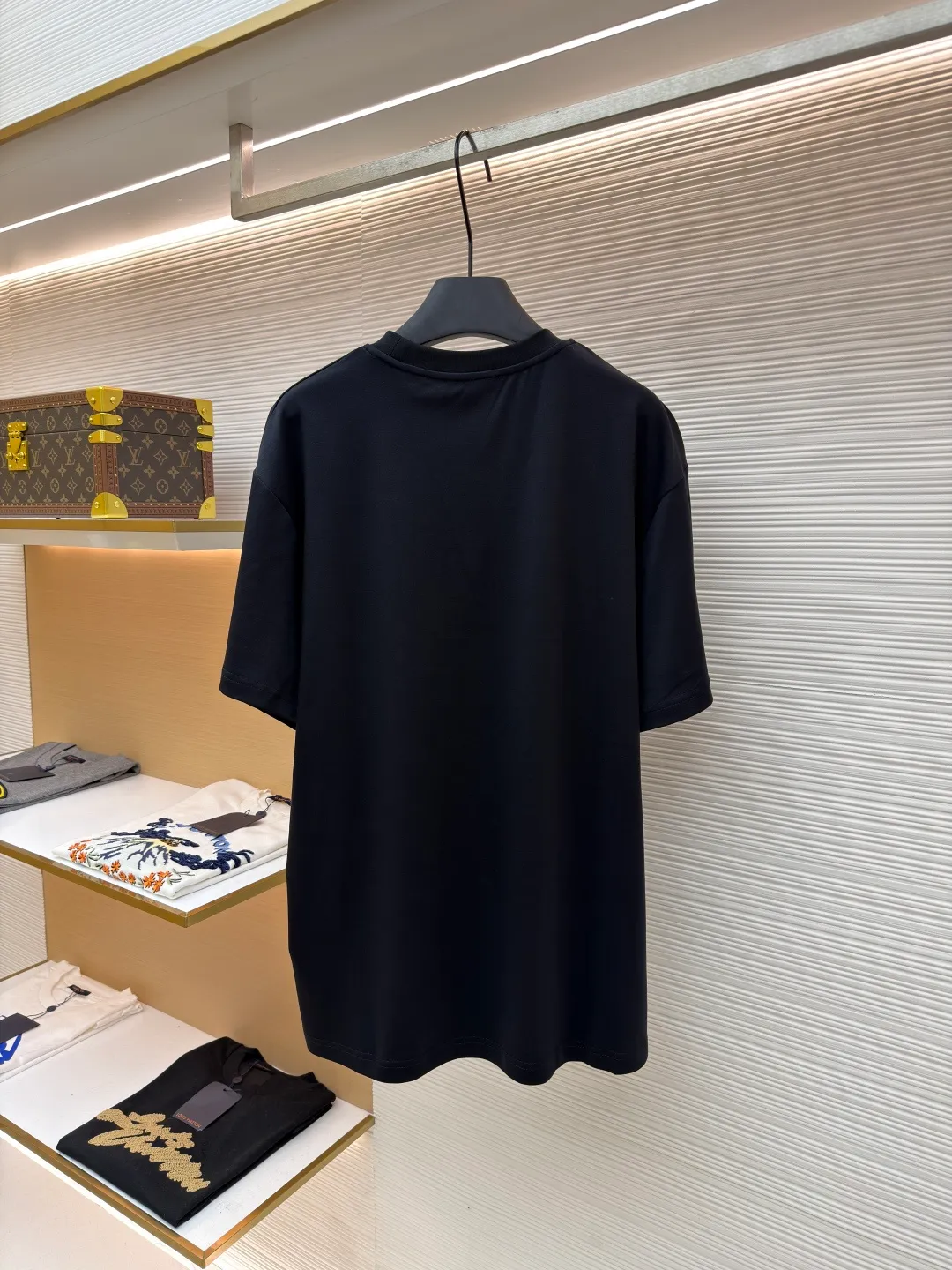 LOUIS VUITTON round neck short sleeves with hand lettering embroidery ●Item number: 1681408-X95 ●Material: long-staple cotton fabric ●Technology: embroidery production ●Color: black ●Version: fitted version ●Weight: about 230 grams ●Size: S-M-L-XL ●Description: Restore 60S single yarn double-sided long-staple cotton, weight 170g; with 32S 1×1 thread, 300g. After being treated with liquid ammonia, it looks like a water-gloss machine. The cloth surface is smooth and has a clear texture, with a slight luster and strong texture. The cotton fiber length of the fabric is long. The advantage of this feature is that after being spun into yarn, the surface of the yarn is smoother, less rough and has a delicate feel. The thin and long features give it a flexible texture, soft skin feel and fabric luster. The front side shows the thickness changes of 3D handwritten font embroidery handwriting strokes and the design pattern after the continuous strokes are simplified; the three-dimensional effect is achieved through multi-layer embroidery threads, filling materials and special stitching methods. Jagged edges are prone to appear on curves and corners; add foam embroidery to the bottom layer of the embroidery and then cut off the excess to form a three-dimensional bulge and improve the smoothness of the lines. Standard H hanging fit with shoulder-length design. The vertical version emphasizes that the width of the shoulders, waist, and hem are basically the same, and it is simple and loose. The short sleeves are tailored to fit the body of the wearer. At the same time, the neckline, cuffs and hem of the short sleeves are all designed with double lines. The overall wiring is straight and delicate, the fabric is comfortable and soft, and the color is consistent without color difference. It can be matched with the same style to create a fashionable look and control various occasions. Customized accessories, complete with three standards, same style for men and women!